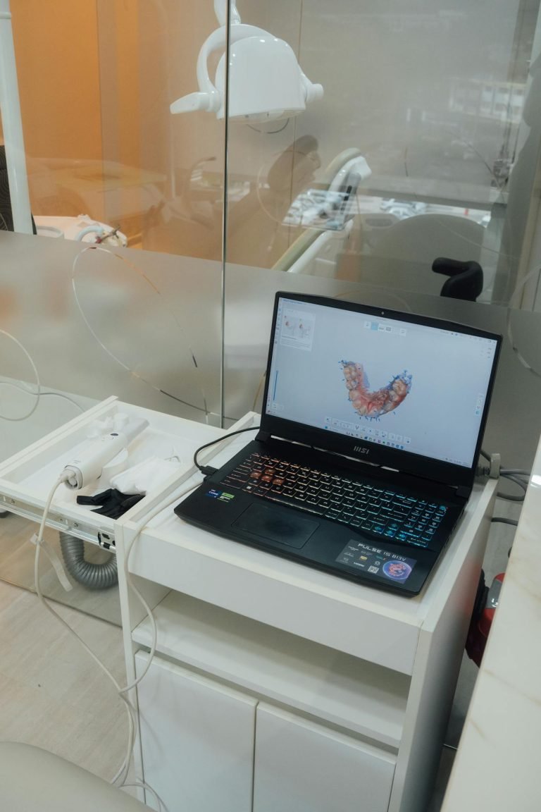 Modern dental office setup with a laptop displaying dental imaging software.